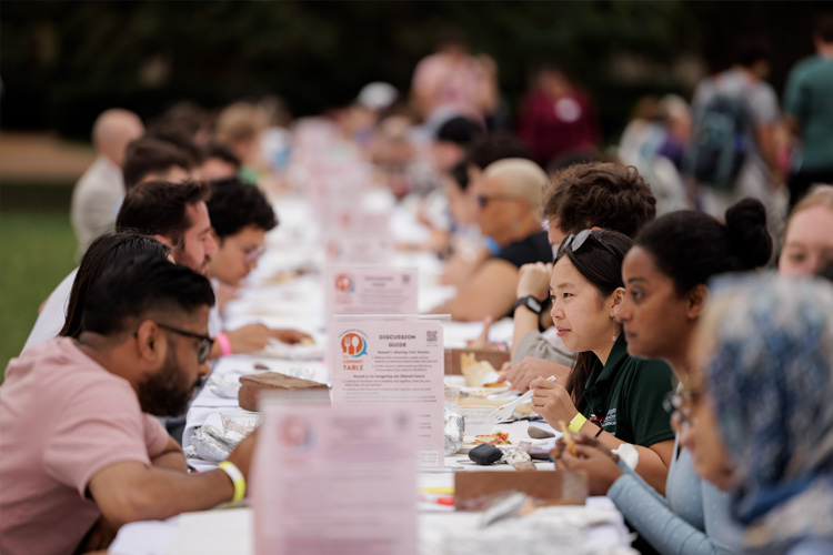 students have a meal and civic dialogue during Longest Table event on campus in Mudd Field